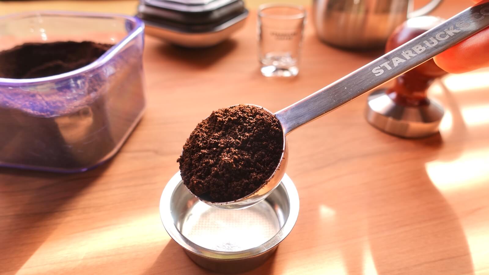 Photo of coffee powder being put into the filter with a measuring spoon